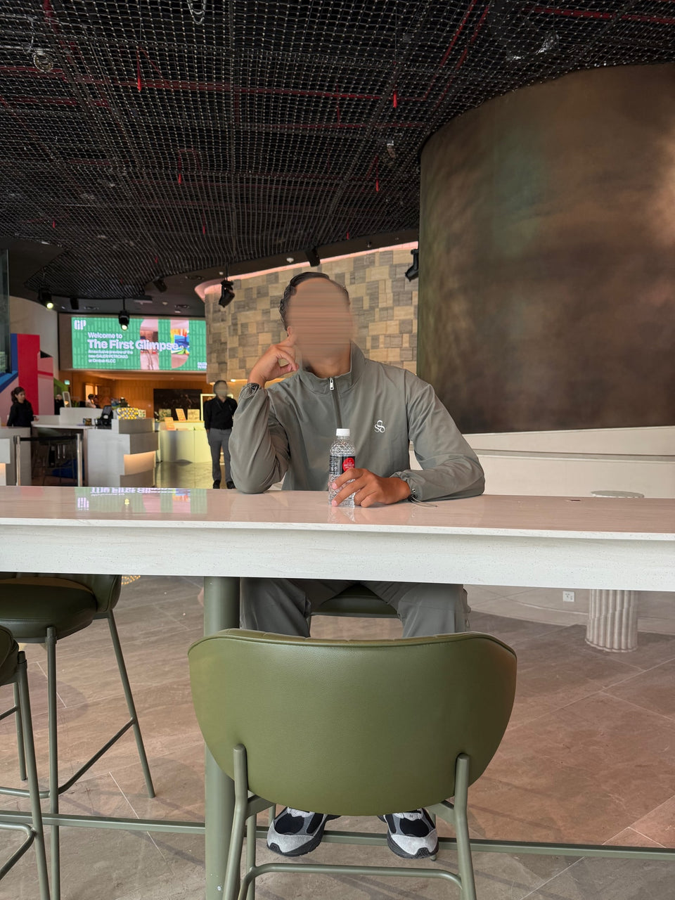 Une tenue grise à une table de café, dans un intérieur lumineux.