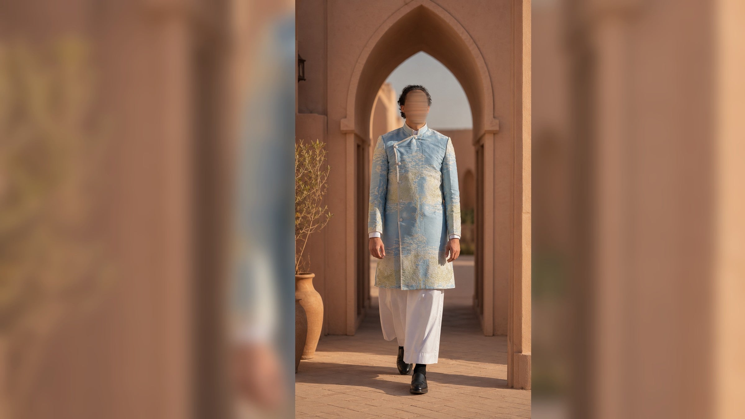 Sawmah - silhouette masculine en cape claire sous une arche